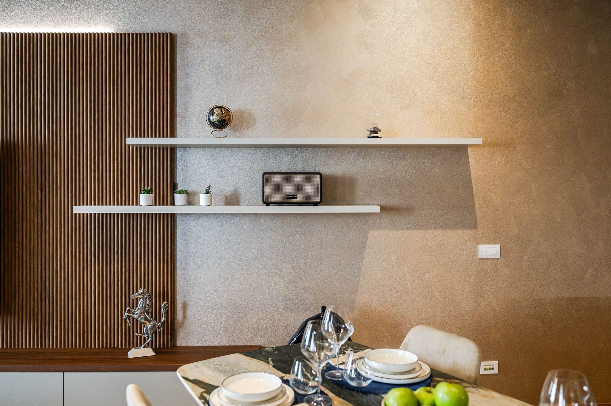 Mensola del living con mappamondo, speaker Bang&Olufsen e cavallino Ferrari