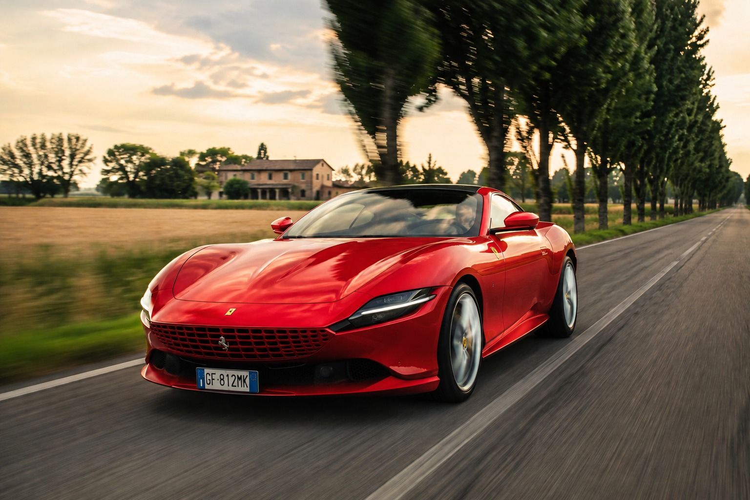 Ferrari Roma rossa in corsa su una strada di campagna
